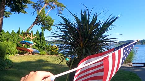 american flag with stars and stripes flies in wind in the garden on the beach slow motion right justified, 4th of july