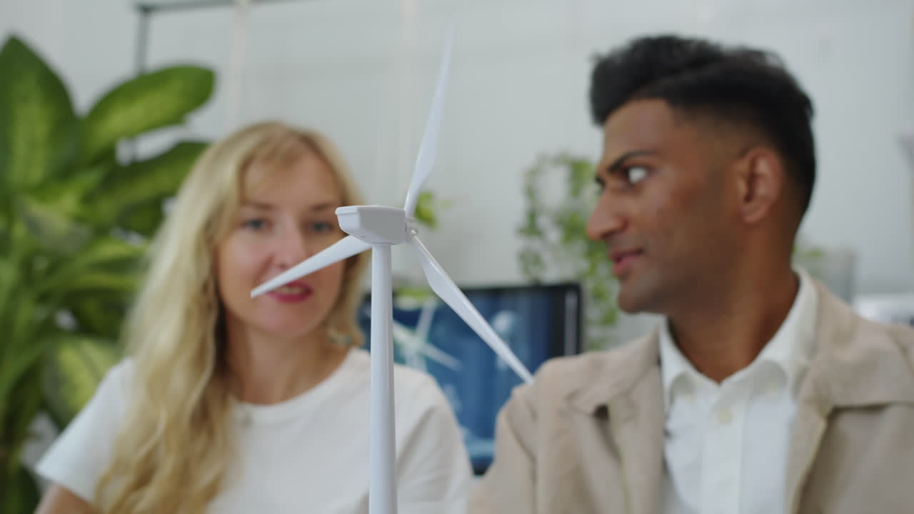 Diverse Coworkers Working on Project, Holding Plastic Model of Wind Turbine
