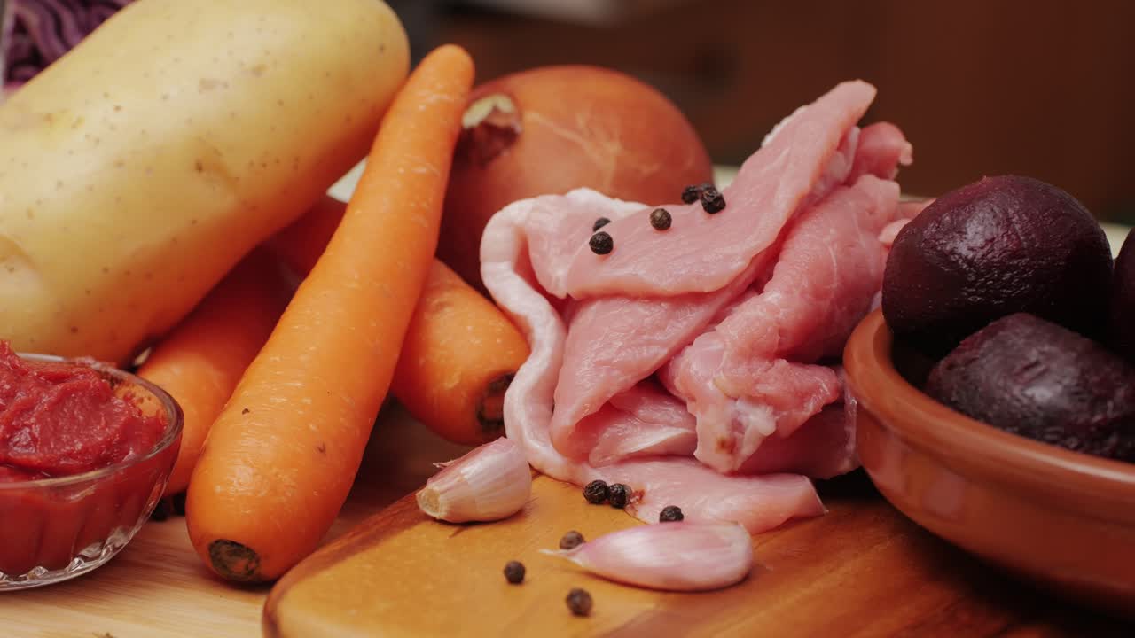 Borscht Ingredients, beetroot soup, Raw fresh vegetables: carrot, cabbage, potatoes, onion, beet, tomatoes pasta and spices and raw chicken. Cooking traditional Ukranian Soviet Union Russian Borsch.