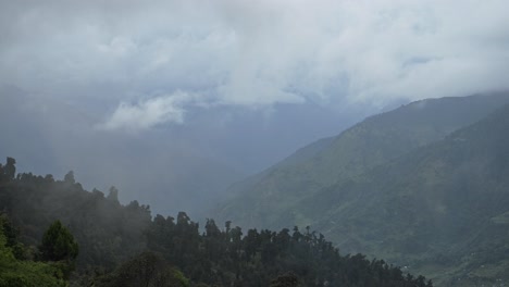 cloud moving through valley in mountains in the himalayas in nepal, trees and forest landscape scenery from above in annapurna region on nepal