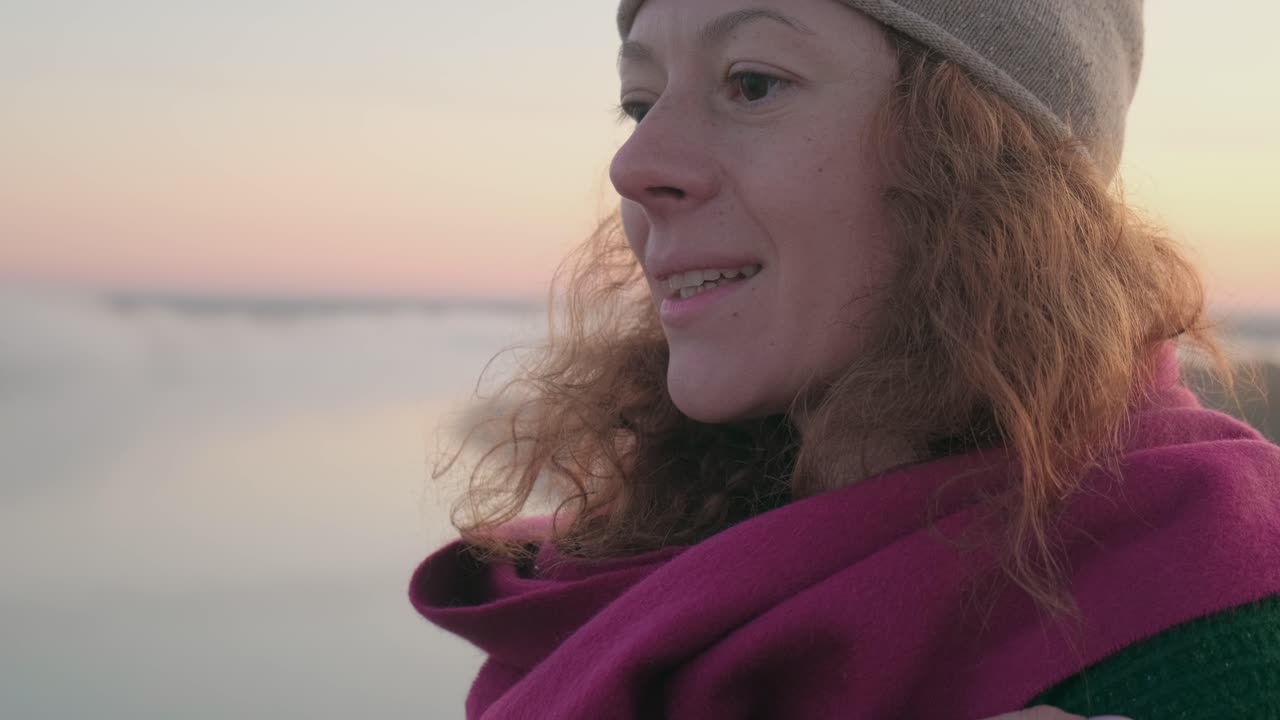 Woman in warm clothing at sunset