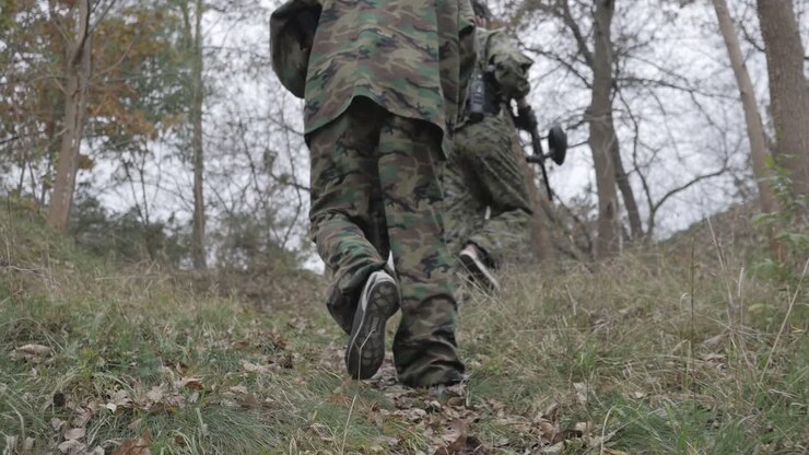 Giocatori di paintball camminano nella foresta al rallentatore