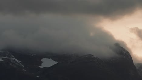 nubes tormentosas iluminadas por el atardecer giran sobre las montañas cubiertas de nieve en el video timelapse
