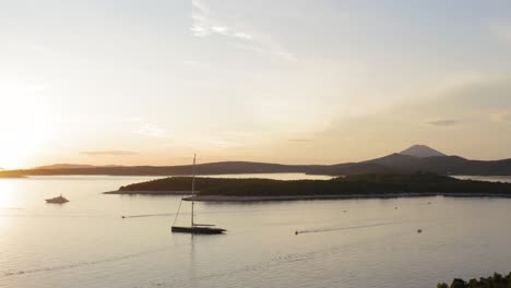 sailboat cruising on adriatic sea by the island of losinj during sunrise in kvarner bay, croatia