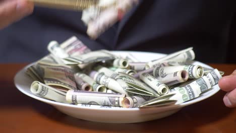 las manos de un hombre de negocios con palillos y rollos de dólar. comiendo dólares. 4k.