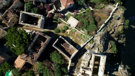 Vista-Aérea-De-Las-Paredes-De-Una-Casa-De-Piedra-En-Ruinas-Y-De-Los-Tejados-Derrumbados-En-Un-Pueblo-Costero-Jónico:-La-Historia-De-La-Muralla-Medieval-En-Riesgo-En-Albania