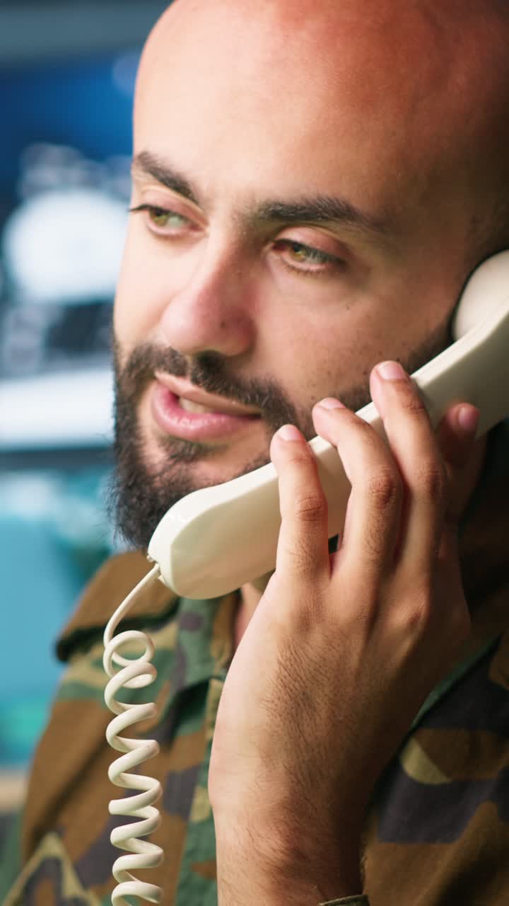 Vertical video Military soldier in mission control center answering telephone call