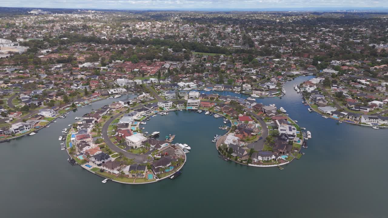 Breathtaking aerial orbit of James Cook Island’s luxury waterfront homes in Sylvania Waters, Sydney, NSW, showcasing beautiful residential properties and serene coastal surroundings.