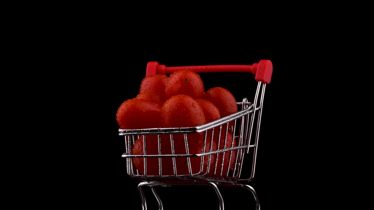 빨간 포도 토마토가 쌓여있는 슈퍼마켓 트롤리의 매크로 촬영, 물방울로 둥글고, 검은 바탕에 고립되어, 클로즈업.