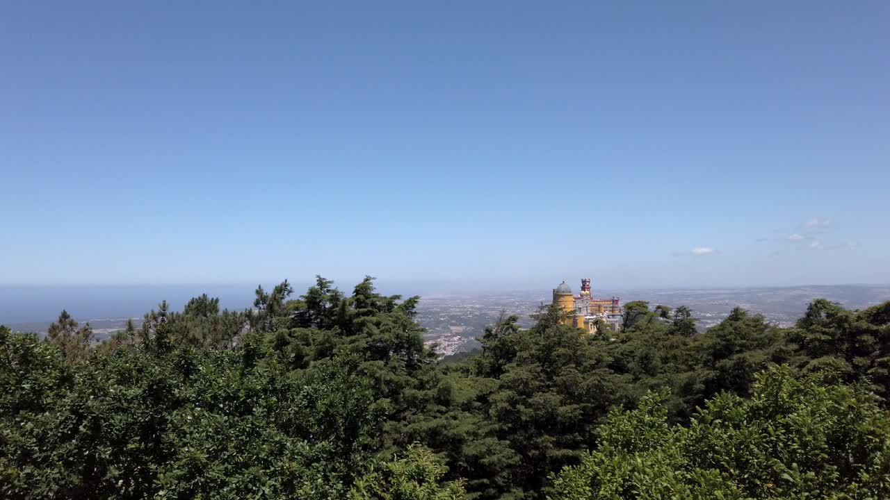 con vistas al colorido palacio pena en portugal elevándose por encima de los árboles en un día claro y ventoso