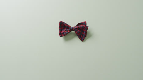 Video-of-red-and-black-bow-tie-lying-on-grey-background