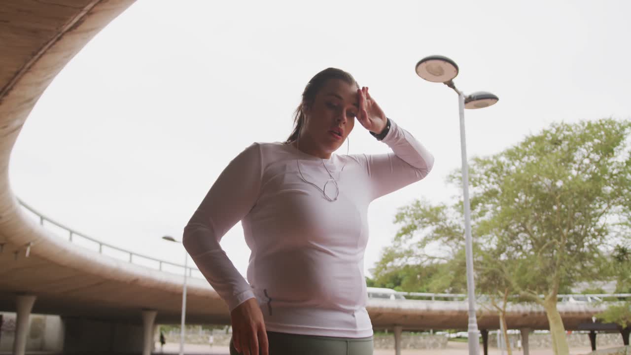 Joven mujer caucásica secándose la frente