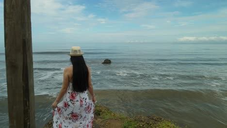 woman walking on wooden cube over a cliff