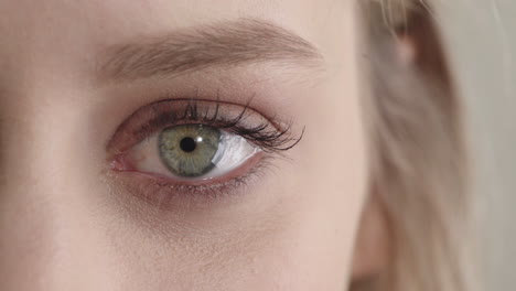 mujer joven con ojos azules abriéndose con maquillaje belleza femenina macro de cerca