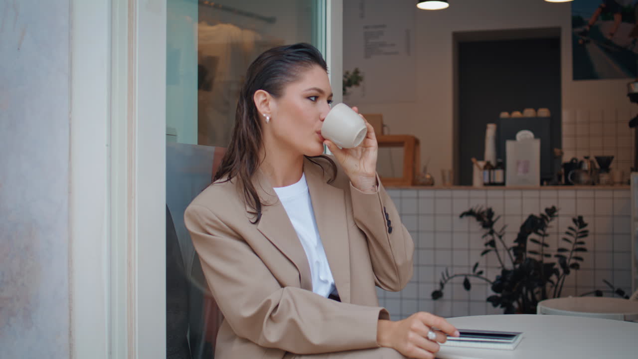 작은 레스토랑에서 혼자 에스프레소를 마시는 미소 짓는 여자. 행복한 여자
