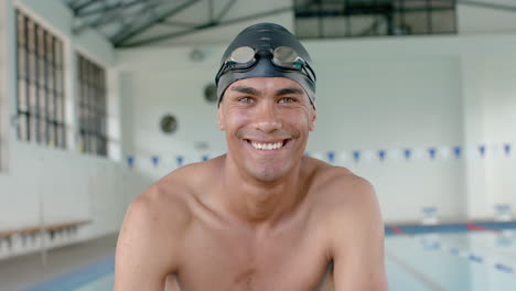 young biracial male athlete swimmer smiles at the camera in a swimming pool