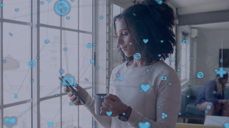 Mid-adult woman holding mug and smartphone by window, tapping and checking floating health icons