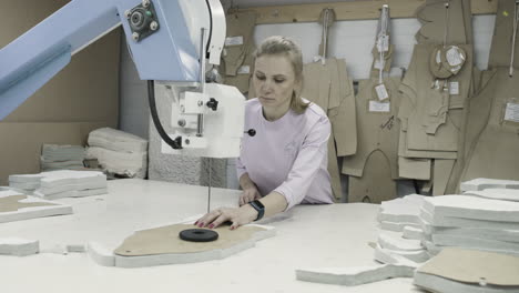 woman working on fabric cutting machine in a garment factory