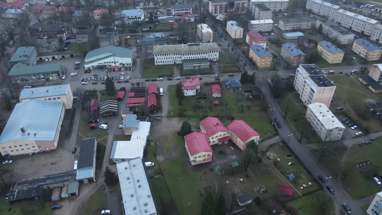 Aerial perspective of Limbazi city showcasing colorful rooftops, historical buildings, a church, and surrounding greenery. A serene, small-town charm is evident in this view.