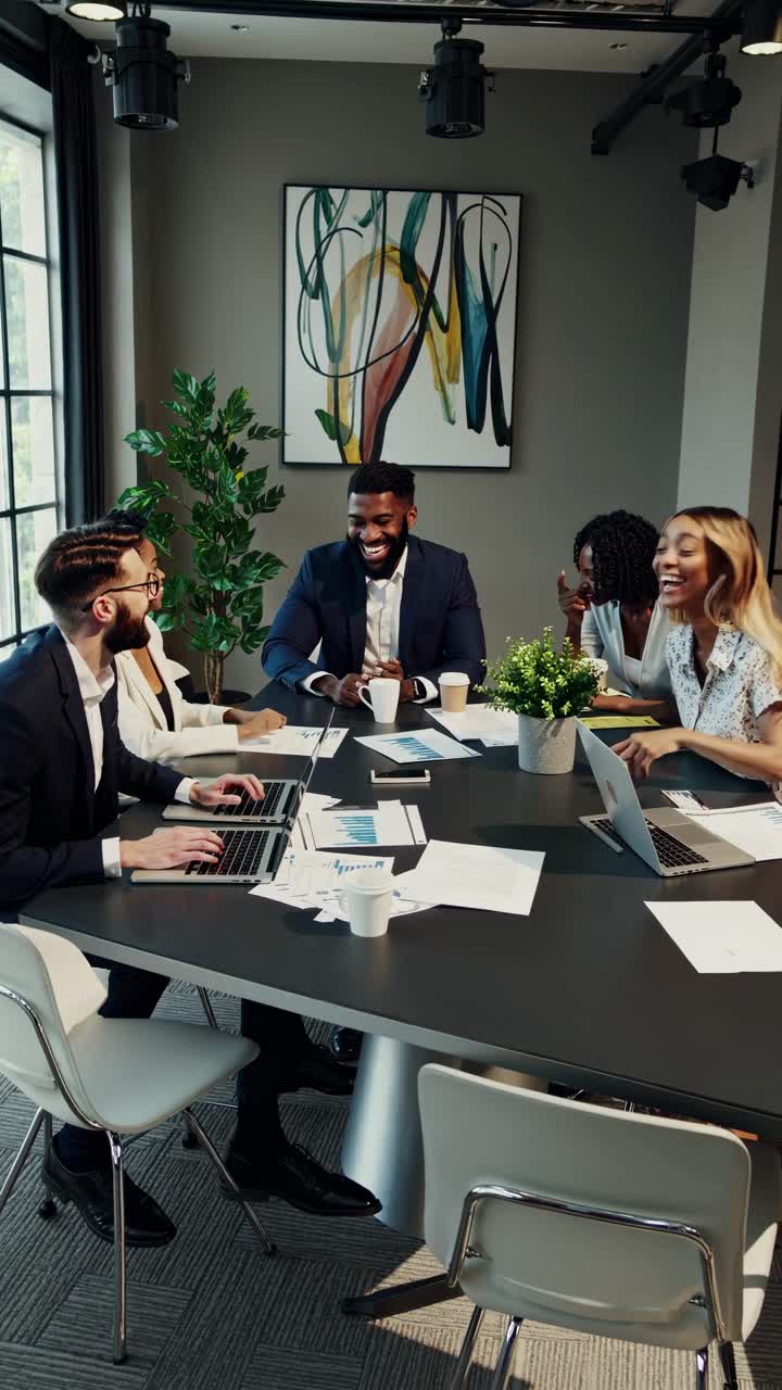 A dynamic video scene of a diverse team in a modern office, captured from a high angle