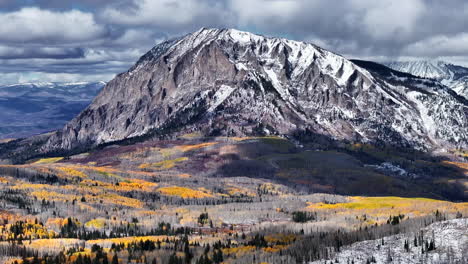 Kebler-Pass,-Filmische-Luftaufnahme,-Drohne,-Crested-Butte,-Gunnison,-Colorado,-Jahreszeiten-Kollidieren,-Frühherbst,-Espe,-Rot,-Gelb,-Orange,-Wald,-Winter,-Erster-Schnee,-Pulver,-Felsiger-Berggipfel,-Kreis,-Bewegung-Nach-Rechts