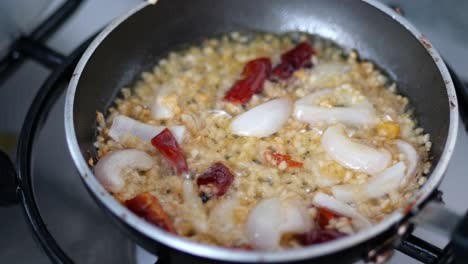 preparing onion, garlic, and chili in a pan