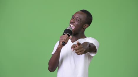 joven africano feliz sonriendo mientras habla en el micrófono