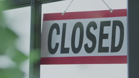 an open sign in the window of a business is flipped to the side labeled closed