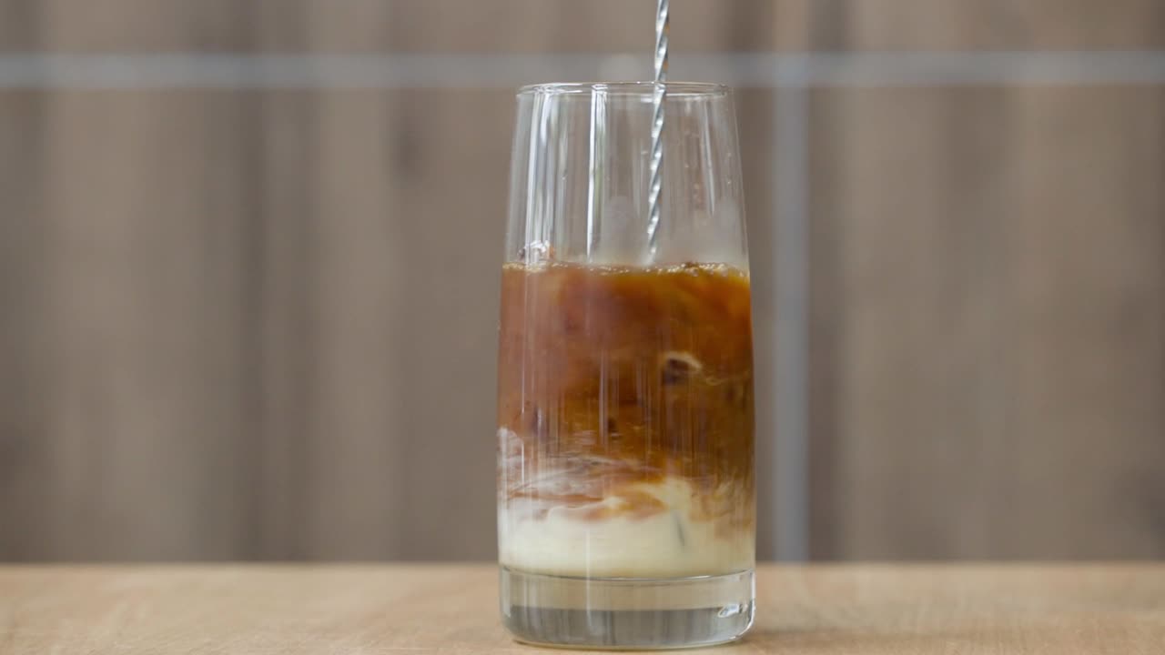 Mezclando leche condensada en café helado vietnamita negro