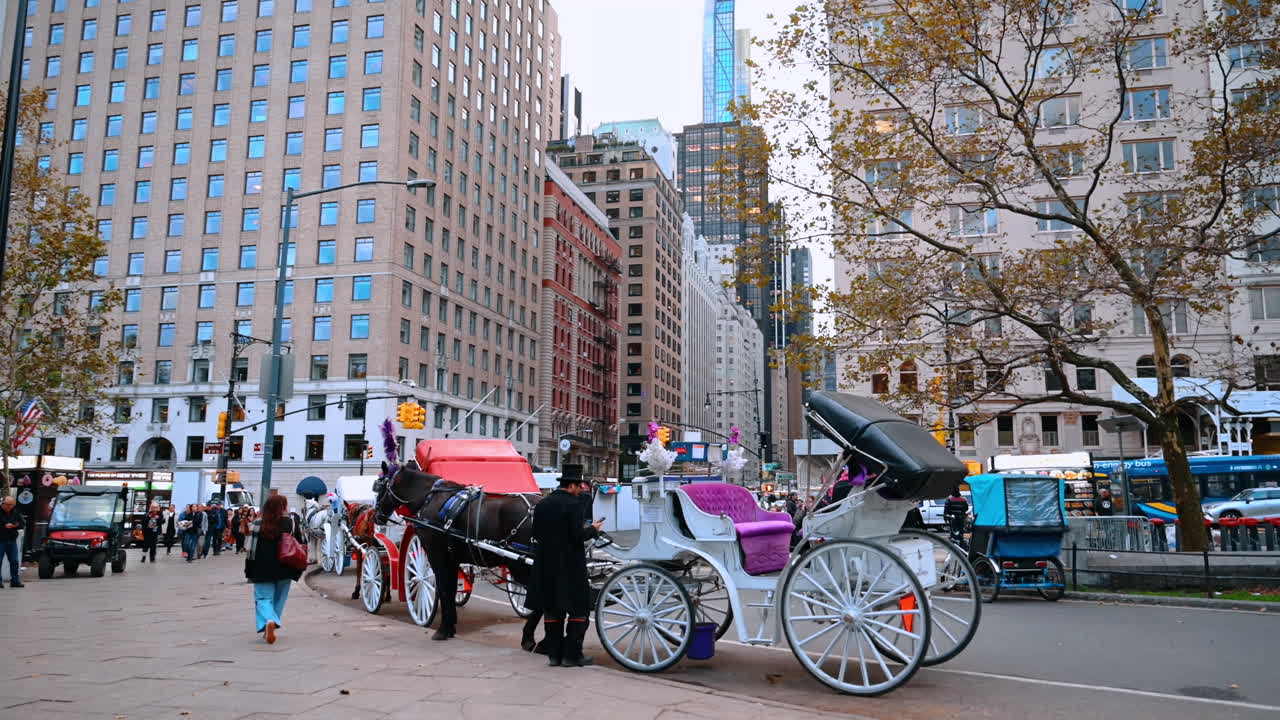 New York, USA, 8 ottobre 2025: strada trafficata con carrozze vicino all'ingresso di Central Park. Pedoni e carrozze trainate da cavalli affollano l'area vicino all'ingresso di Central Park a New York