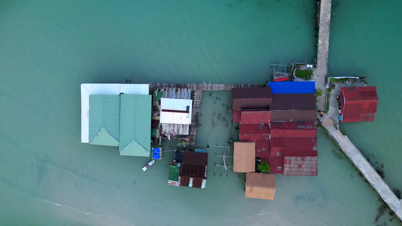 cambodia Koh Rong island, capturing the essence of tropical paradise with its lush palm trees, vibrant turquoise waters, and traditional stilt houses. Best aerial view vertical bird's eye view drone