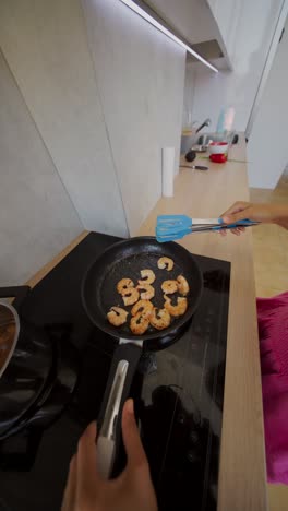 person cooking shrimp in a pan