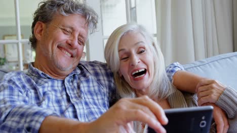 Senior-couple-taking-selfie-on-sofa-4k