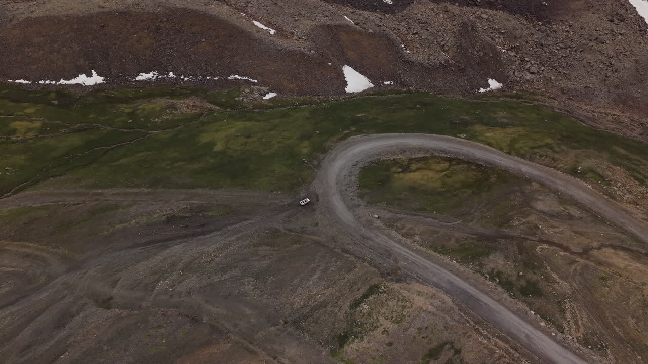Isolated Vehicle View From Above Near Remote Unpaved Mountain Road In Kyrgyzstan, Central Asia. Aerial Drone Shot