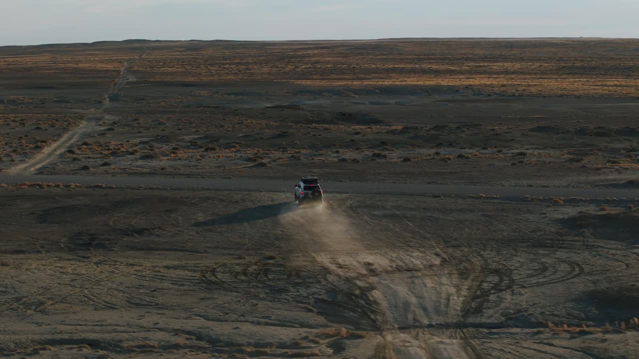 el camión de off-road conduciendo a través del paisaje desierto de moonscape, factory butte en utah, estados unidos
