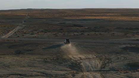 Off-road-car-truck-driving-through-deserted-landscape-of-Moonscape,-Factory-Butte-in-Utah,-USA