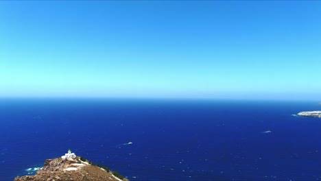 aerial 4k blue sea and sky top view over akrotiri lighthouse towards horizon in santorini greece