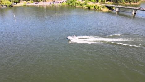 barco de esquí con casco en v acelerando desde la zona de no despertar y navegando en el lago