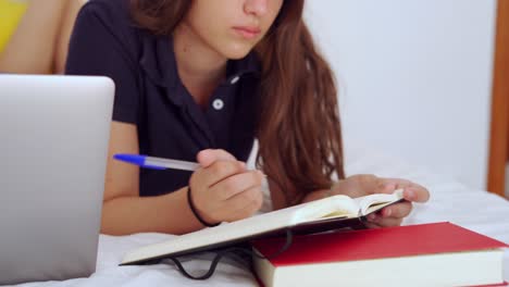 young woman studying online in bedroom