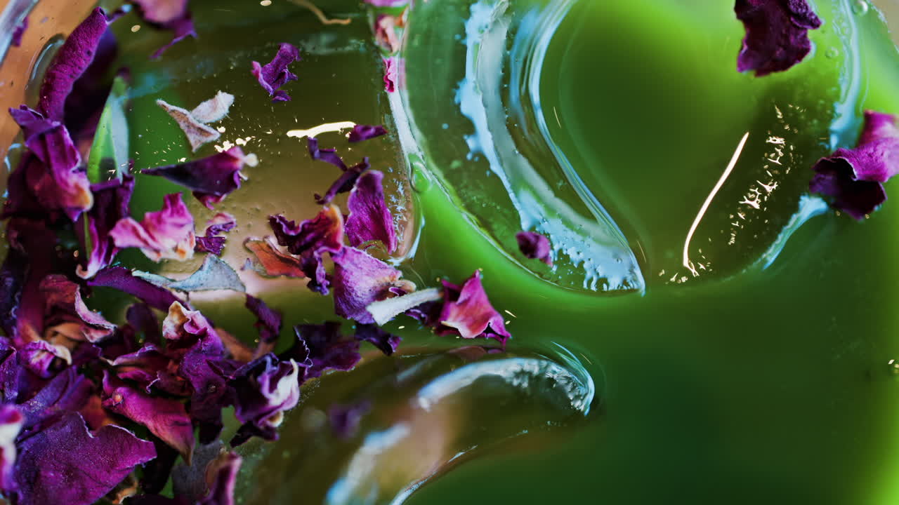 Close up of an iced matcha in a glass with purple dried flowers on top