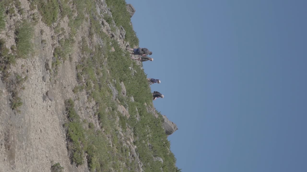 группа людей совершает пеший поход по горам и холмам виллы пехуэния, патагония, аргентина, с голубым небом над головой