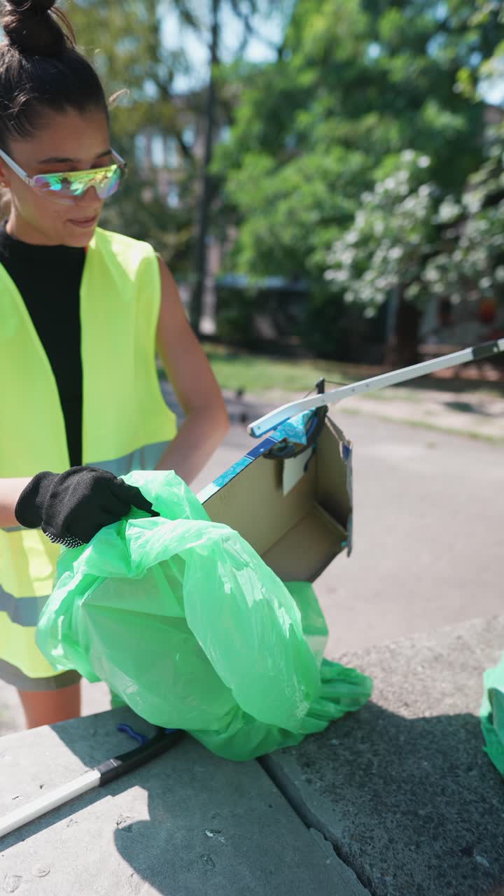 mujer limpiando la basura en un parque
