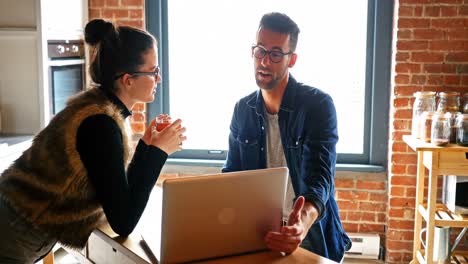 pareja interactuando entre sí mientras usan una computadora portátil mientras