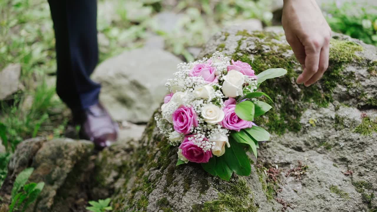Wedding bouquet with beautiful flowers in the hands of the groom. Handsome man holding a bouquet.