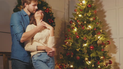 couple embracing by christmas tree