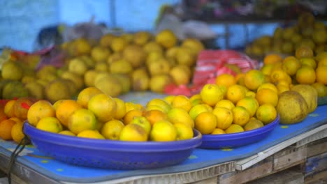 bandejas de frutas cítricas de naranja colocadas en la mesa, filmadas de cerca en cámara lenta de mano