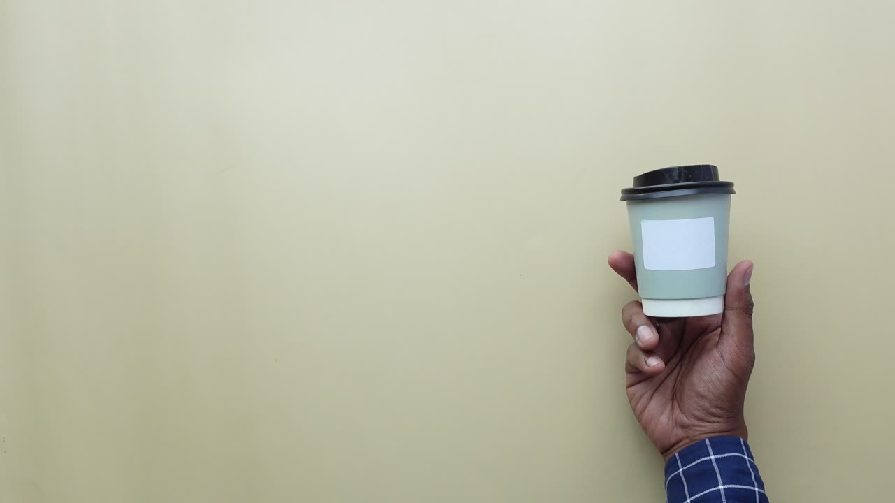 mano sosteniendo una taza de café de papel
