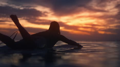 Woman-Paddling-on-Longboard-at-Sunset-in-Costa-da-Caparica,-Portugal