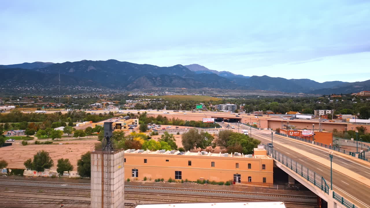 Colorado Springs, USA, 22 July 2025: Lots of cars ride quickly by the roads in the cityscape of Colorado Springs, Colorado, USA. Vast city scenery with mountain range at backdrop