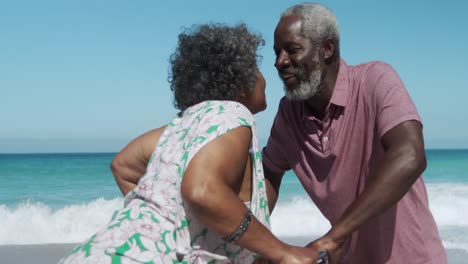 una pareja de mayores besándose en la playa.